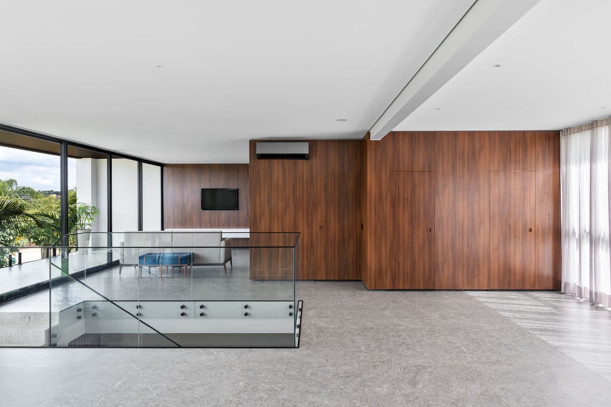 Sala ampla com painel de madeira que esconde as portas