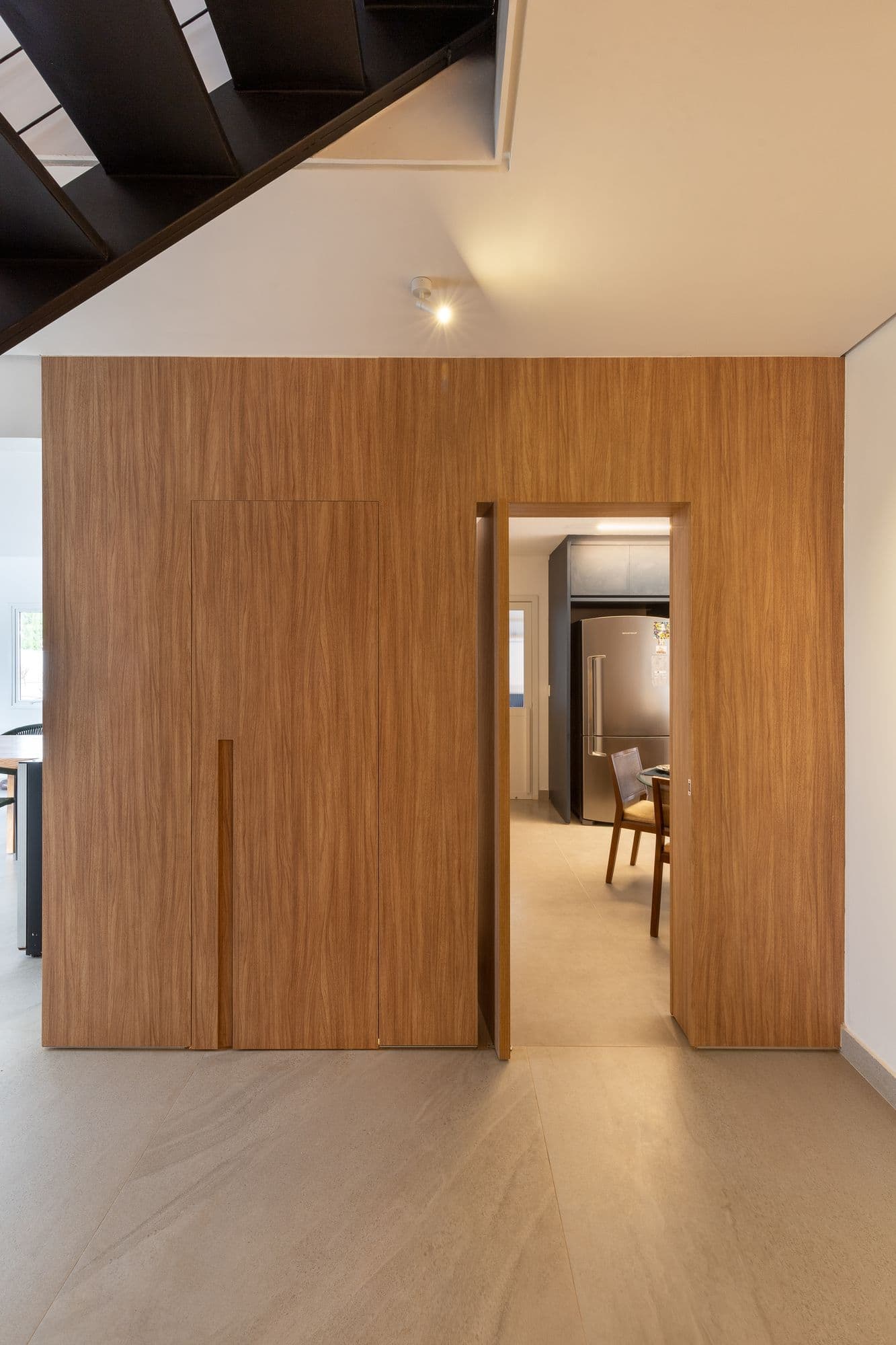 Painel de madeira com a porta oculta aberta para a cozinha